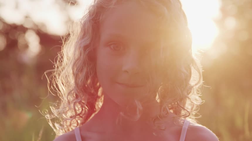 A girl is standing outdoors in spring at dusk