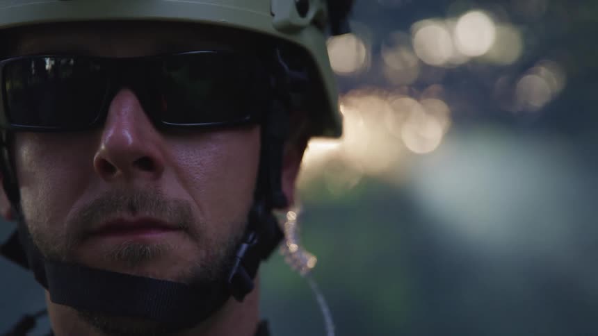 Soldier wearing sunglasses and a helmet standing outdoors