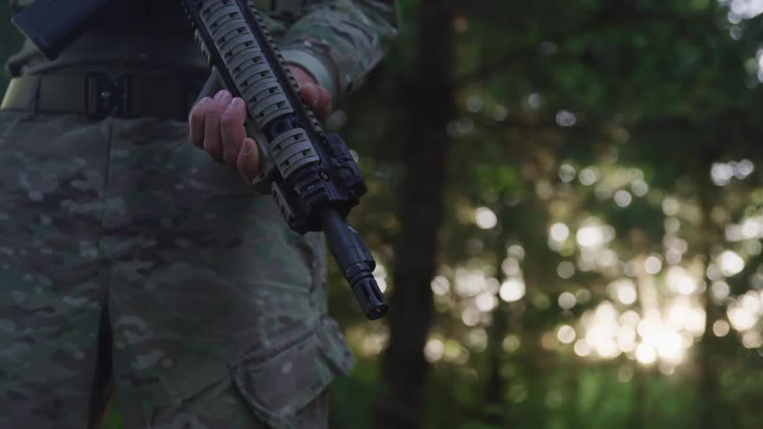 A soldier holding a gun outside