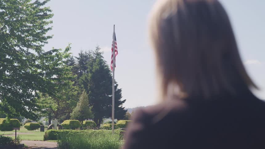 A woman standing at a flag