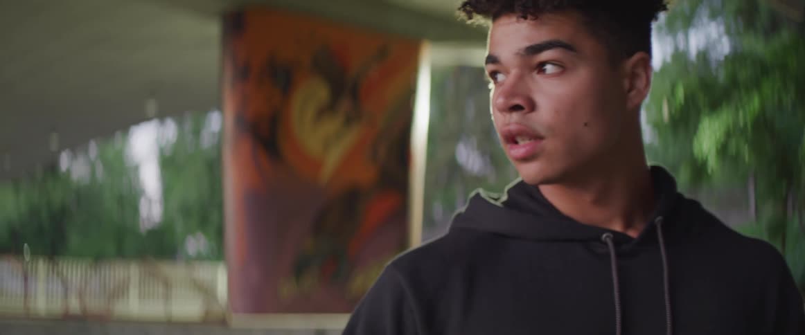Man wearing a black hoodie staring at the camera