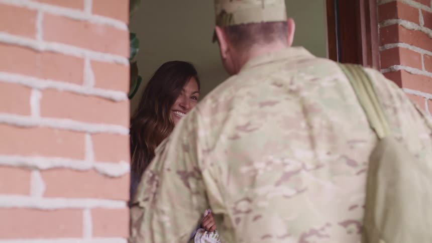 Us army soldier returning home hugging wife and daughter at home