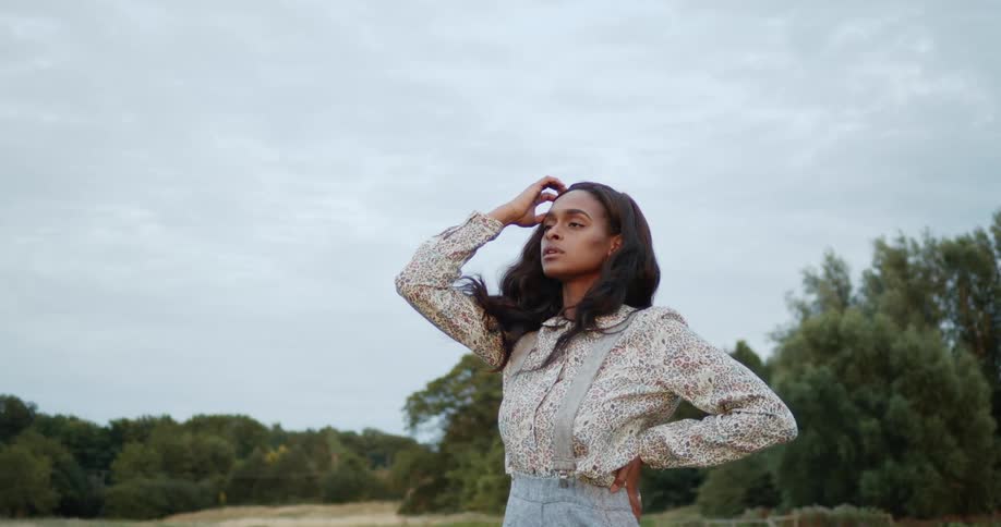 Woman posing for a fashion photo shoot in the middle of a grass field