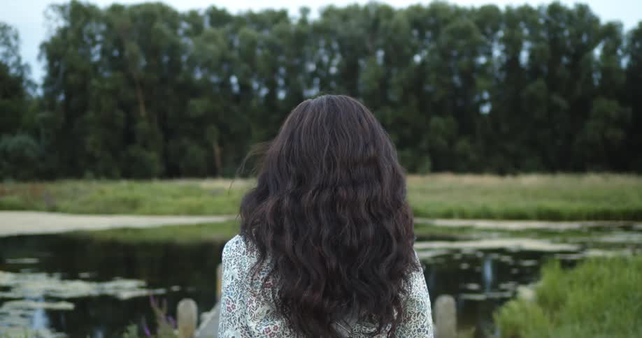 A woman walking towards abody of water