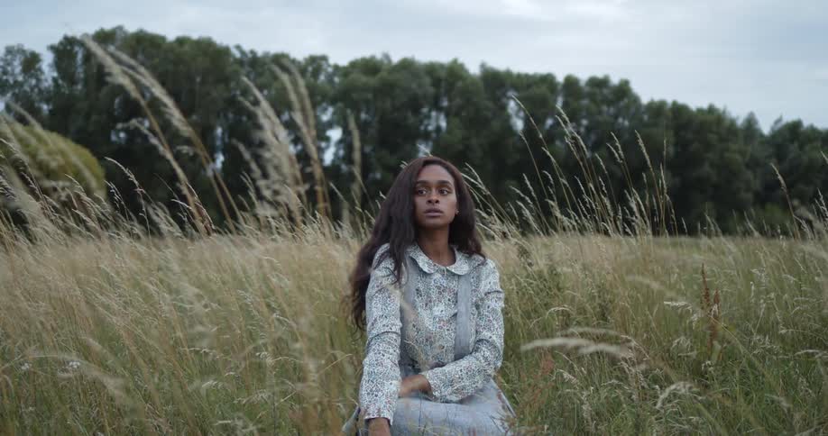 A young woman sitting in a field of grass