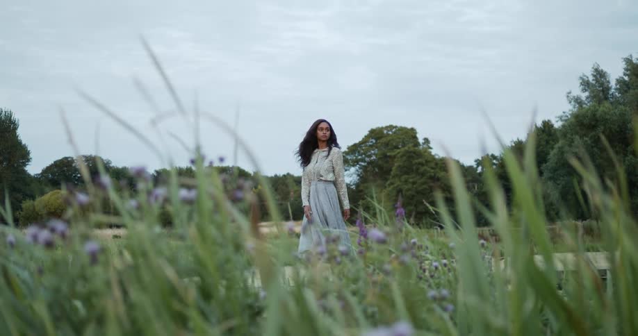 A woman spins around on the windy field