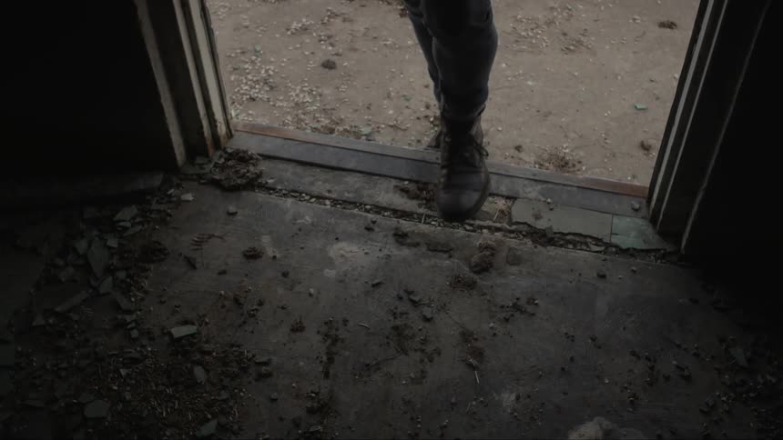 A man walks into a dark room from outside