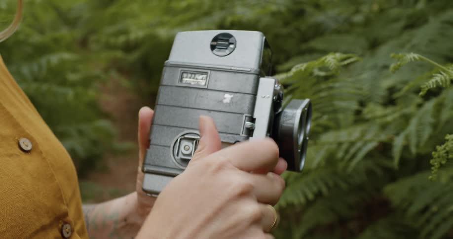 A woman is turning the lever on a camera