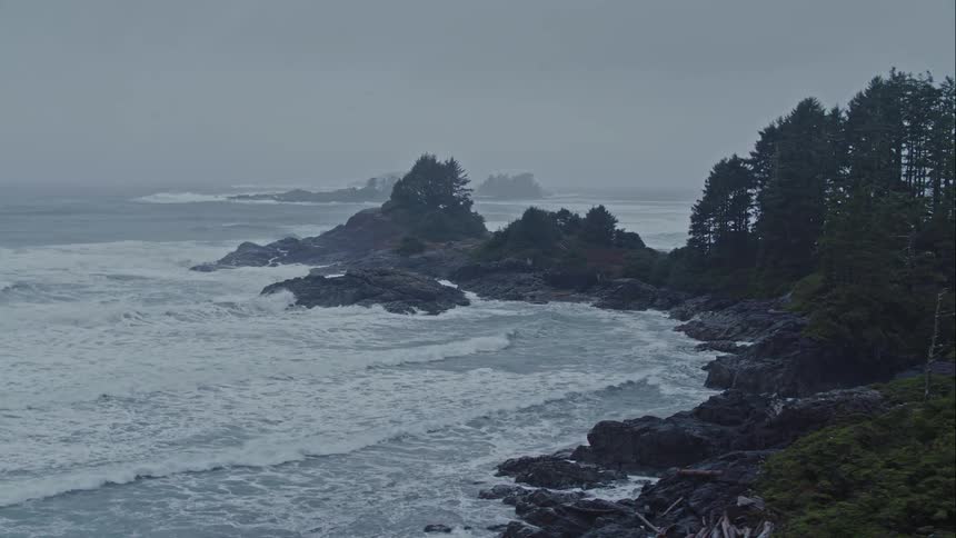 Ocean waves form and break on a rocky shore on a stormy day
