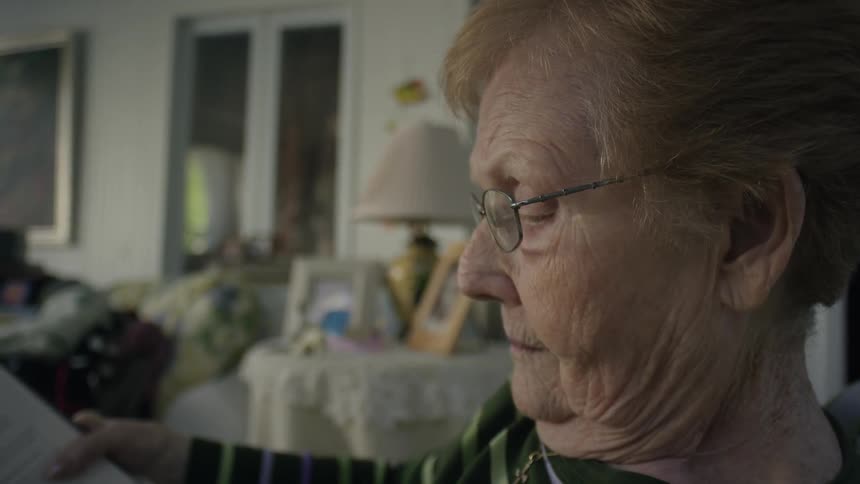 An elderly woman reads a book