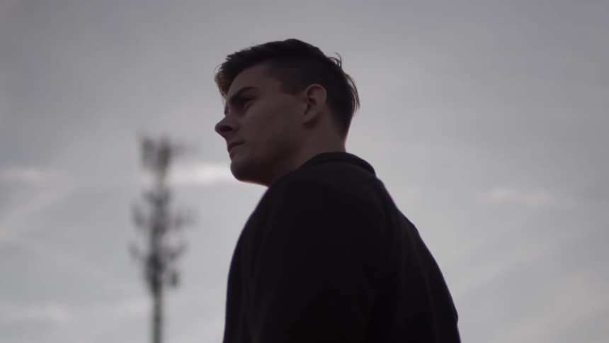 A man stands outside on a cloudy day