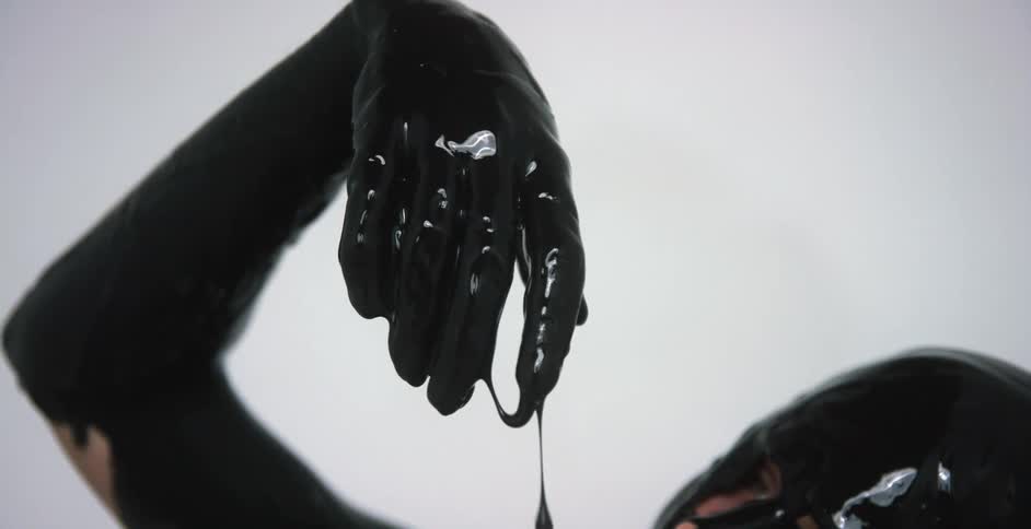 A person covered in black paint with a white background