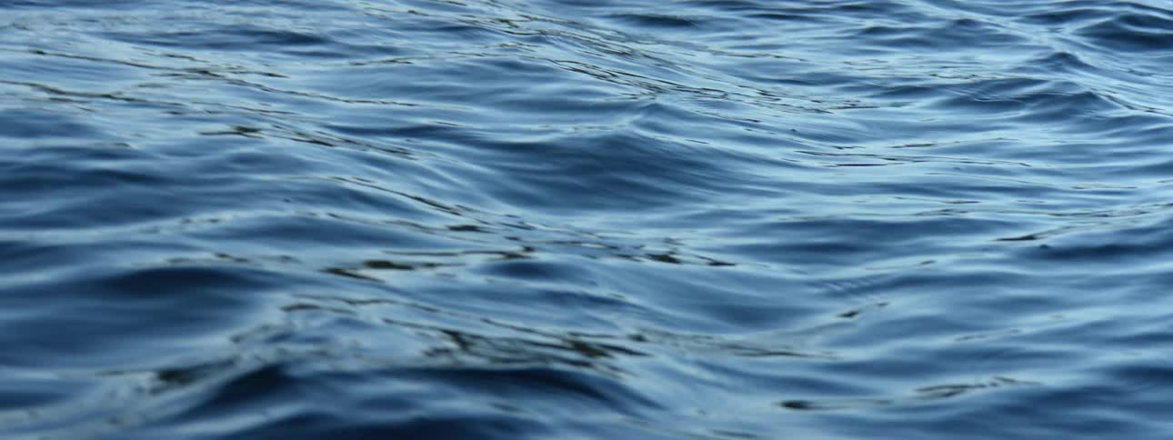 Twisting footage of the small waves over the surface of the ocean at evening