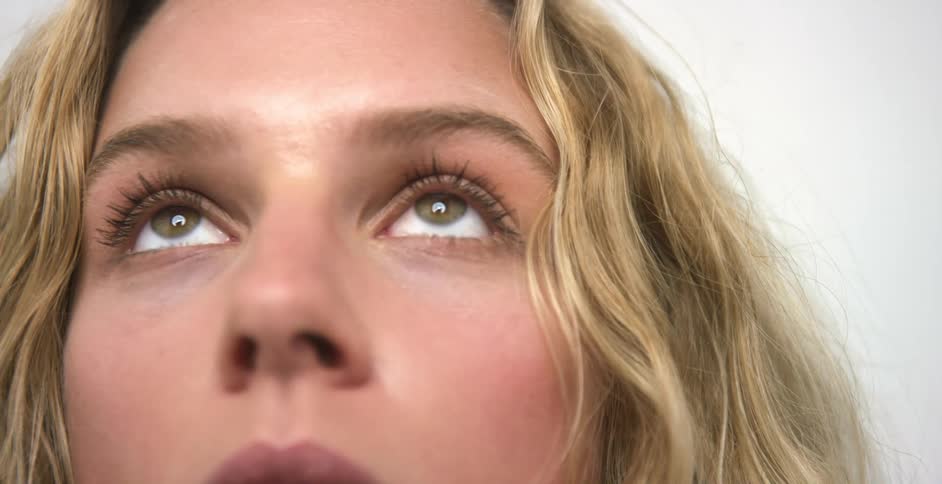 White woman looking above her while facing the camera