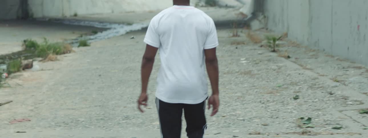 Man walking under a bridge underpass at daytime