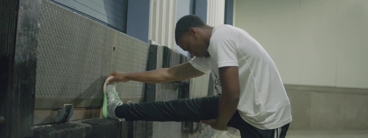 Black man wearing fitness clothing and stretching out