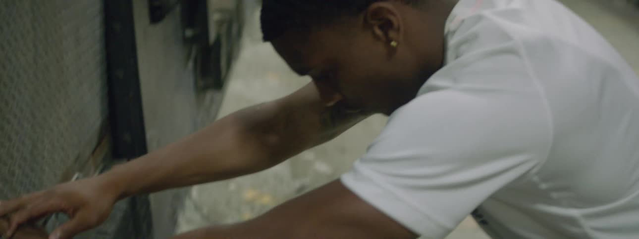 Young fit man stretching against the wall on a parking garage before jogging