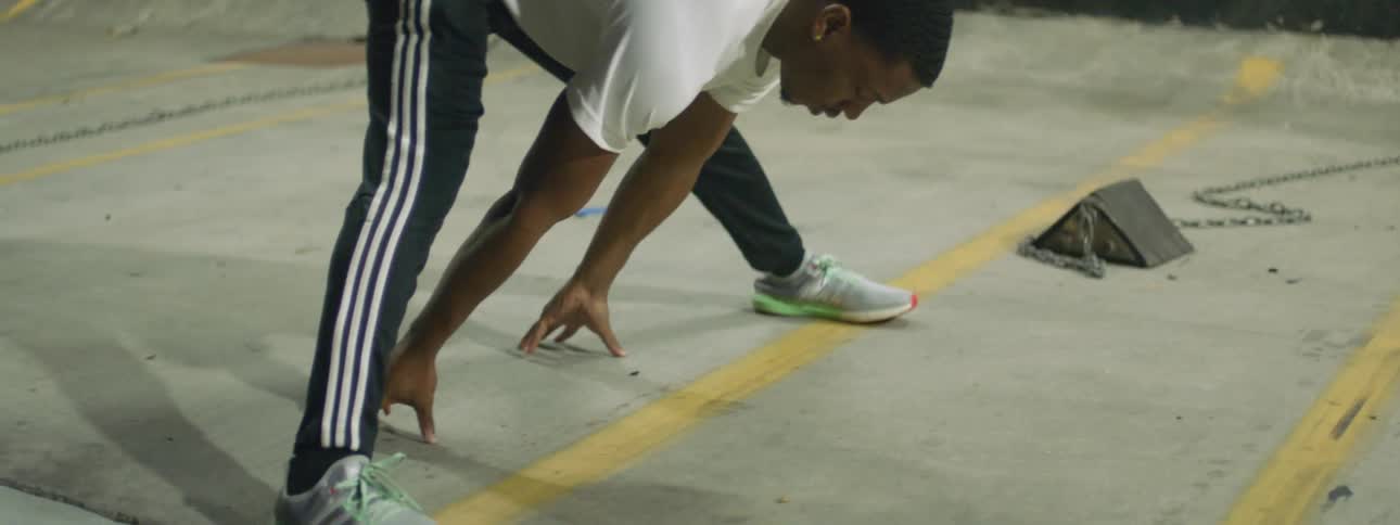 Black man stretching out alone in a parking lot