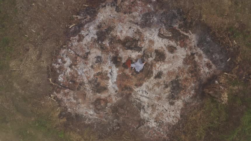 Birds eye view of a woman lying lifeless on the ground