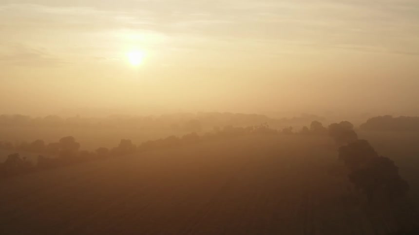 Sunset in a very hazy orange sky and land