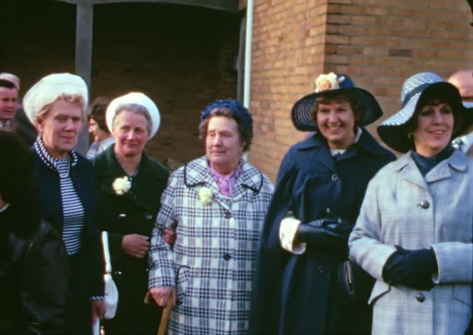 A group of elderly people gather for a photo
