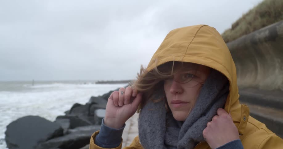 A woman is standing outdoors next to the coast