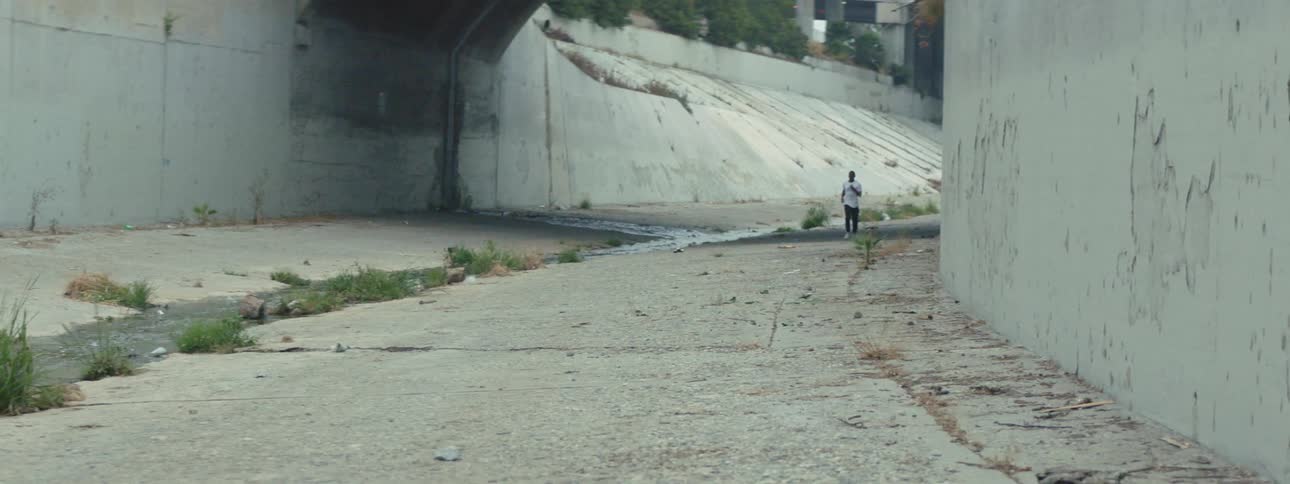 A man running in a storm drain