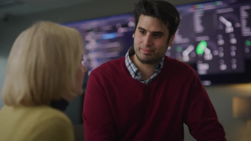 A man and woman are talking in a room together