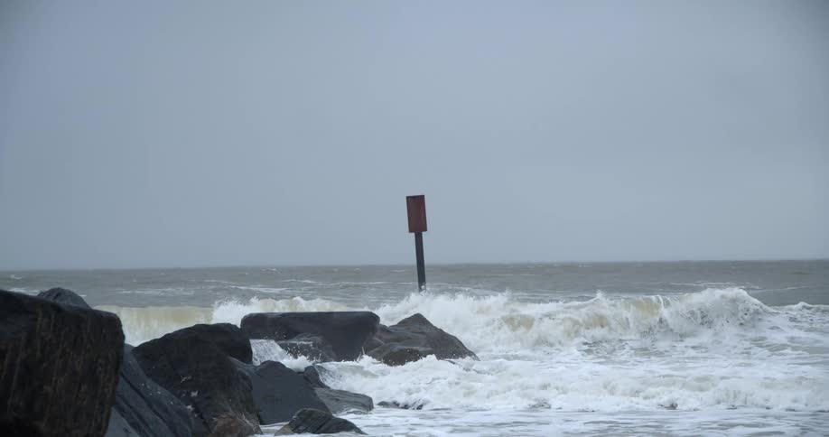Ocean waves crashing on the rocks in the coast on an overcast day