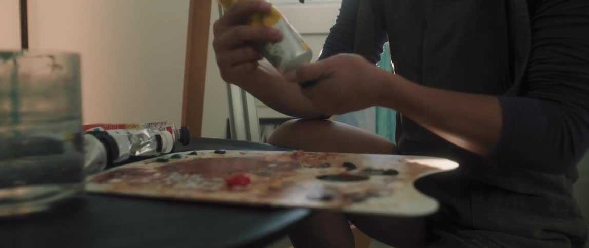 An asian female putting paint onto a paint palette