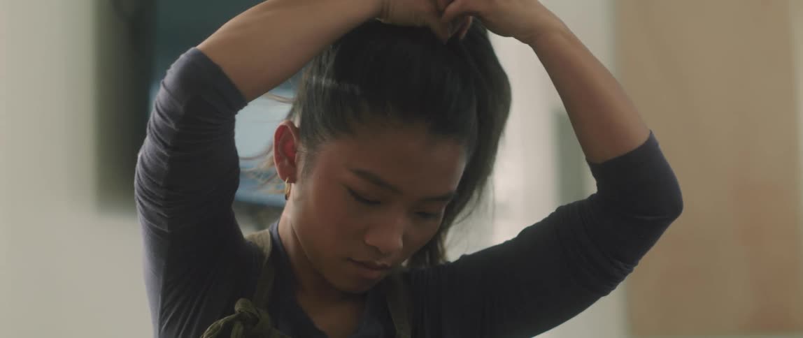 A woman is putting her hair in a ponytail
