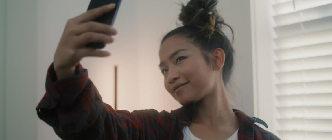 A girl is taking selfies inside a house