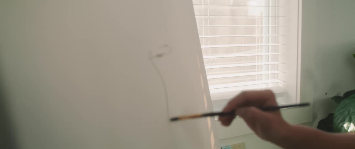 Woman drawing in an empty canvas and smiling