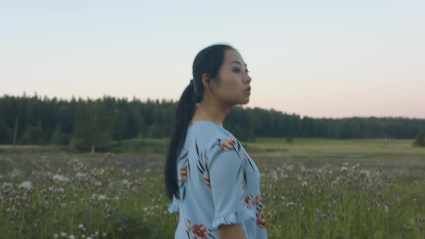 A woman is walking outdoors at dusk