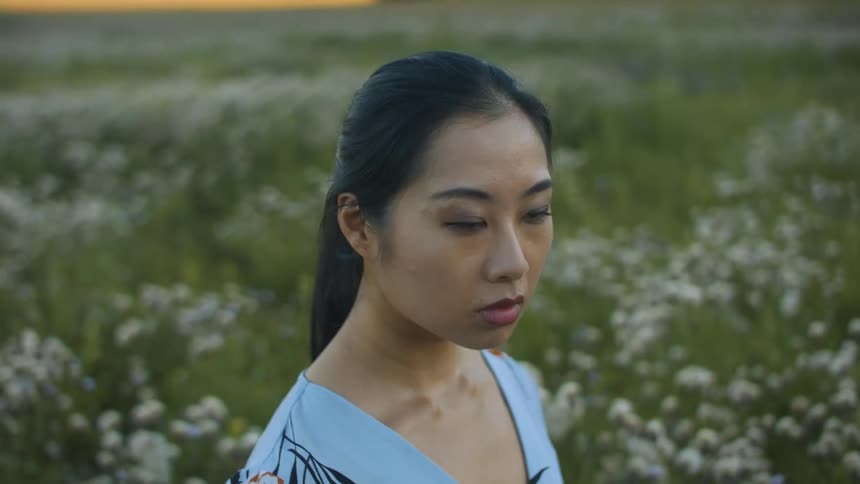 A woman is standing in a field of flowers