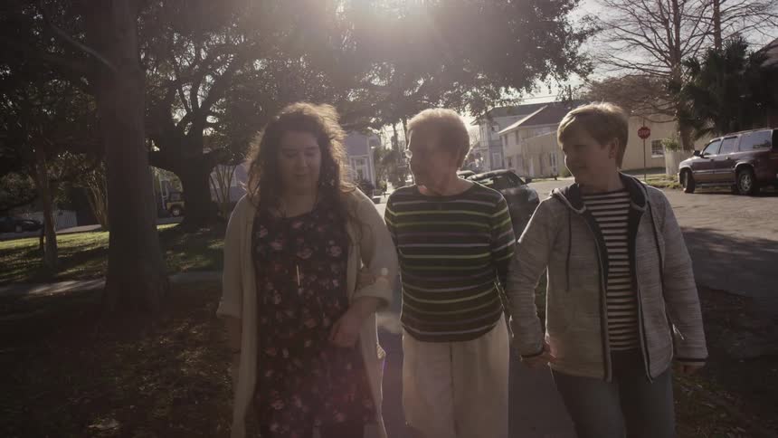 Three woman walk down a sidewalk