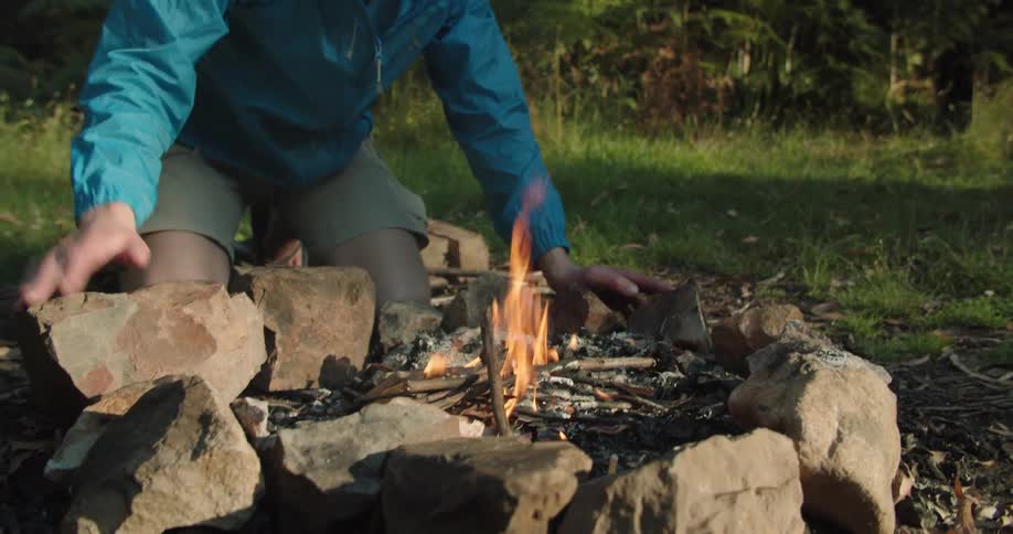 White man starting a bonfire at the middle of the forest