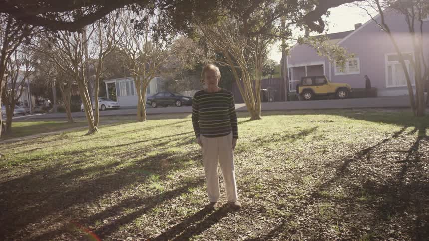 A man stands in a park in the suburbs