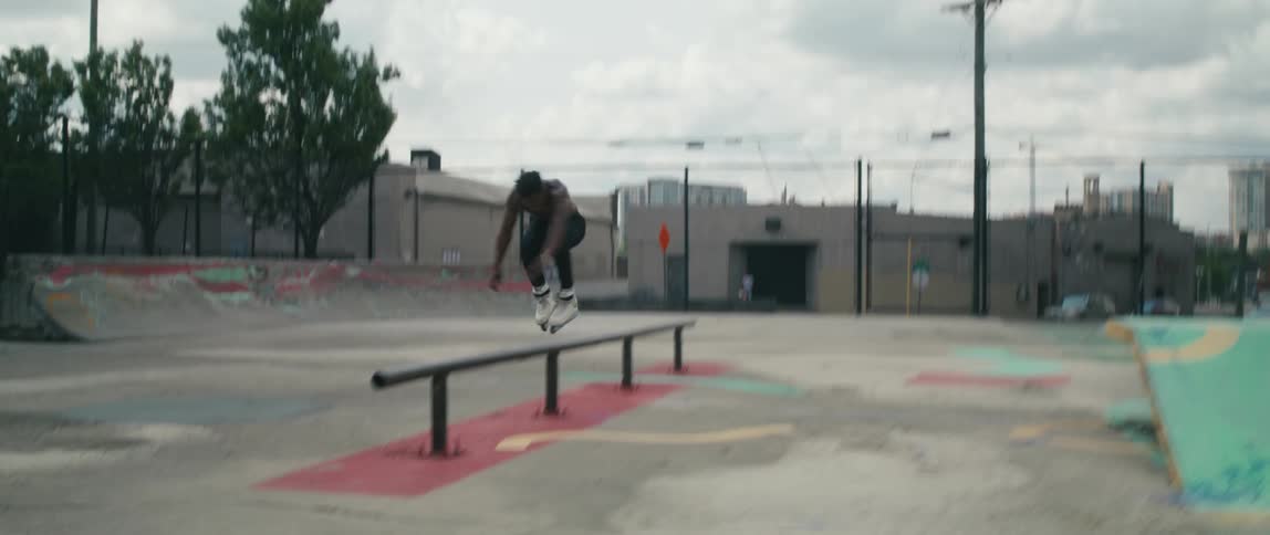 A man is roller blading at a skate park