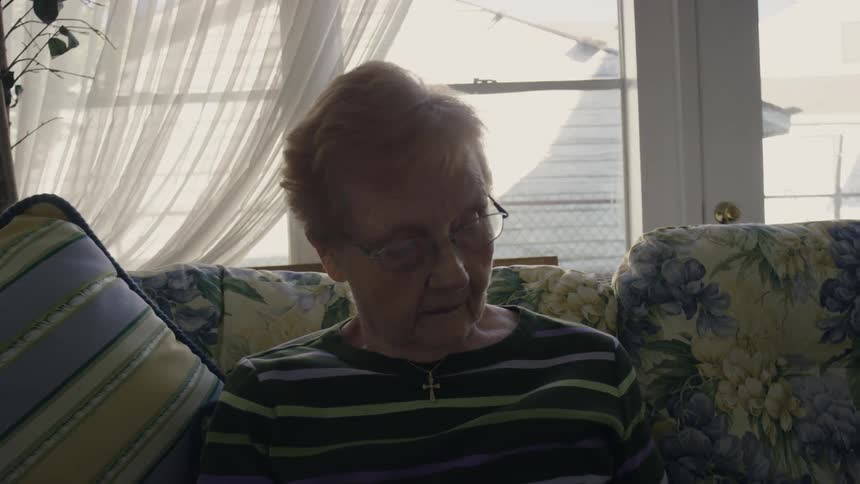 An elderly woman sitting on a couch