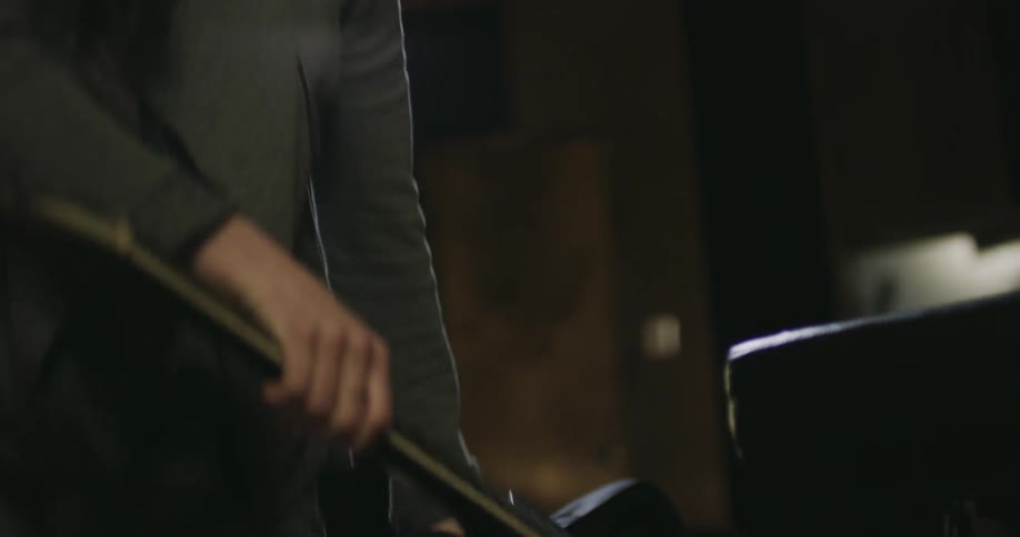 A woman opens a case and removes a guitar
