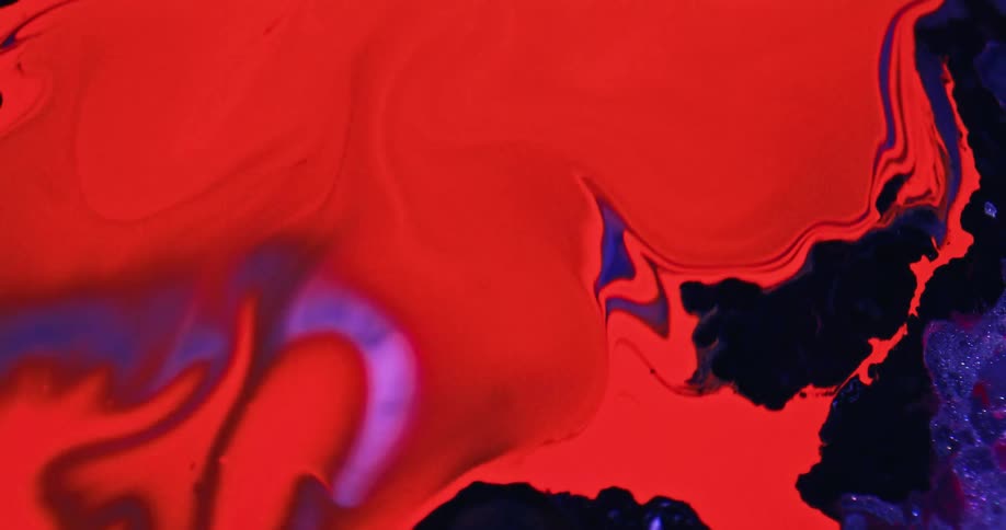 Red and blue liquids swirl together under a microscope