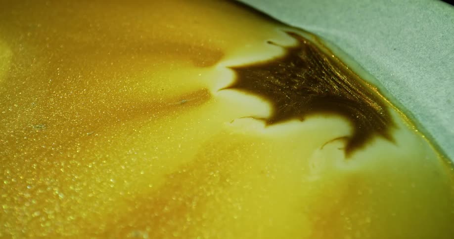 Brown breaking apart on a gold bubbly surface