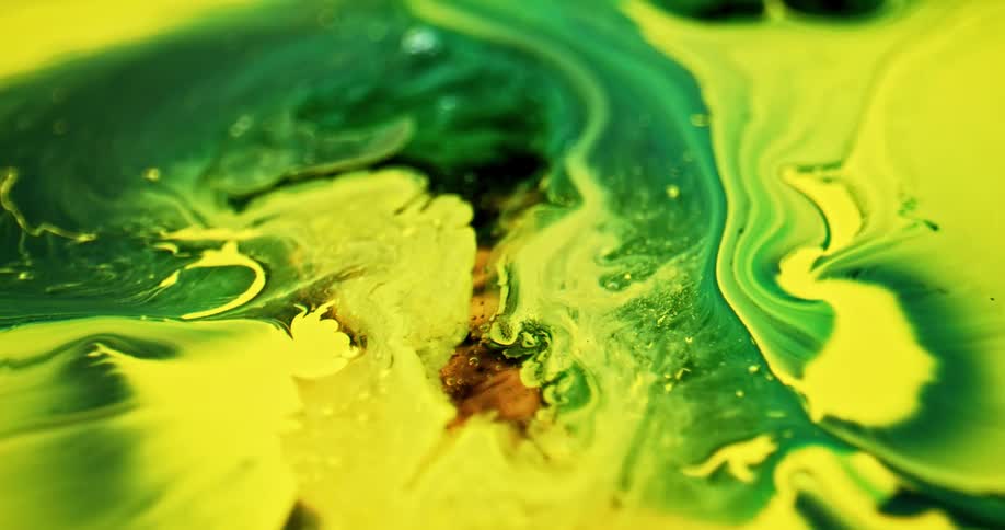 Close up of yellow and green paints moving around