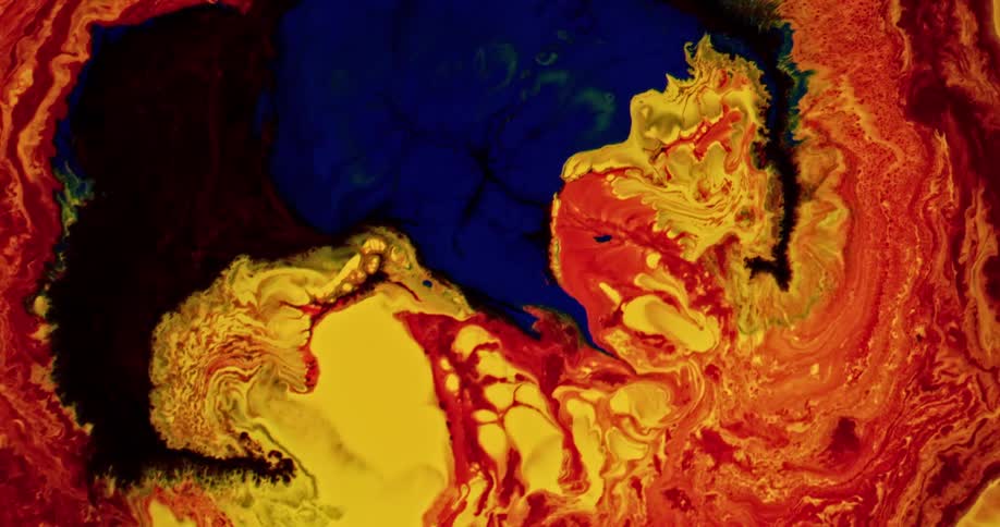 Bright colored liquid inks pouring over a surface forming abstract chaotic patterns
