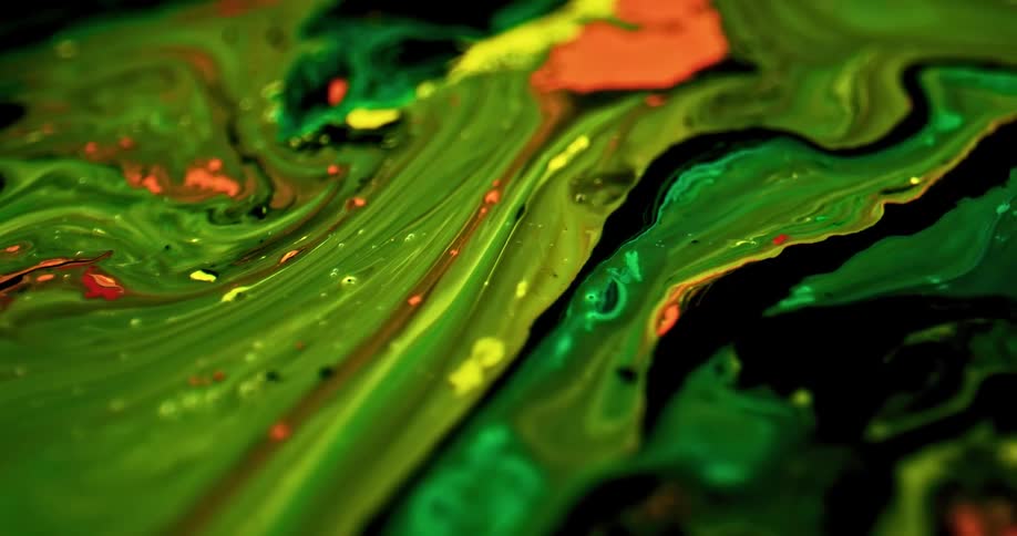 Orange green yellow and black paints swirling together and moving downwards