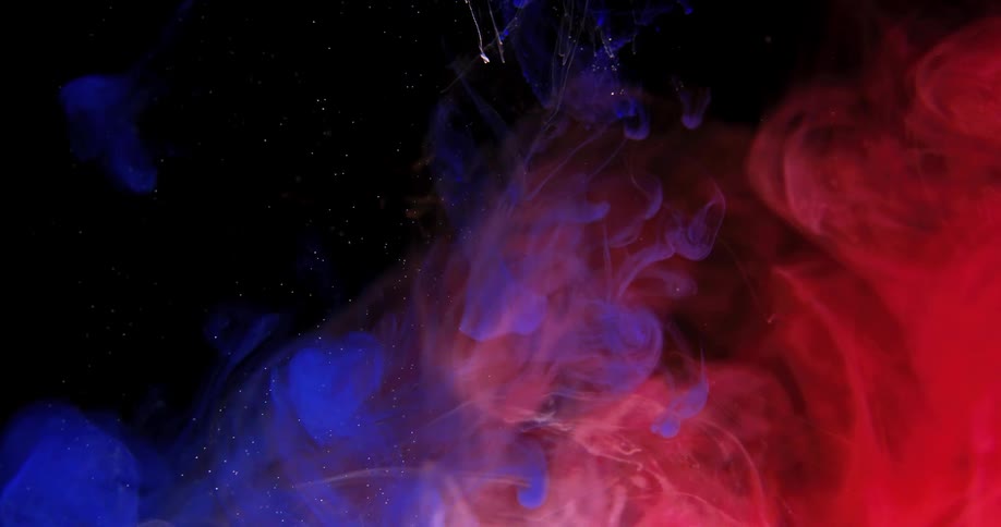 A shot of blue smoke is added to a black liquid and combines with red smoke