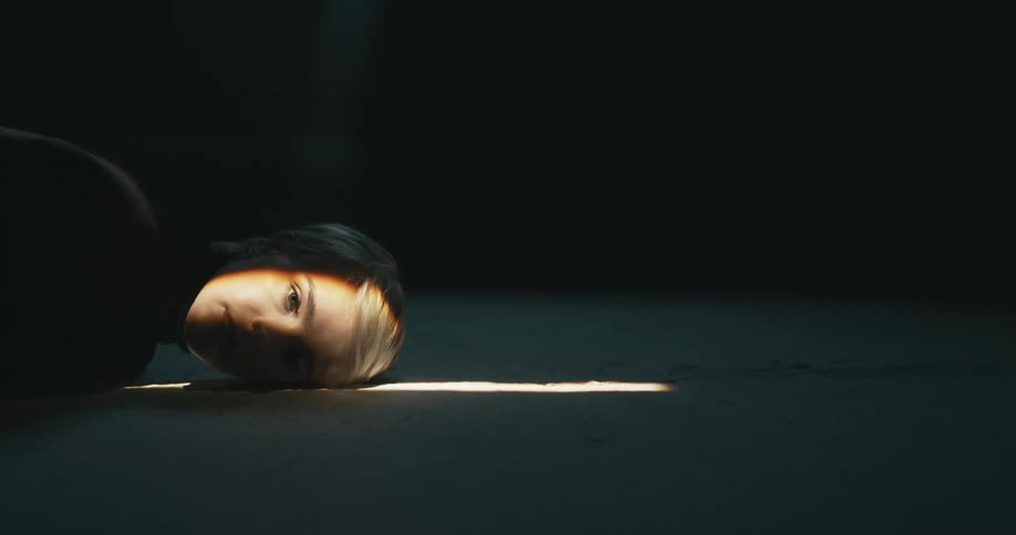 Blonde woman lies on the ground and sunlight shines on her face