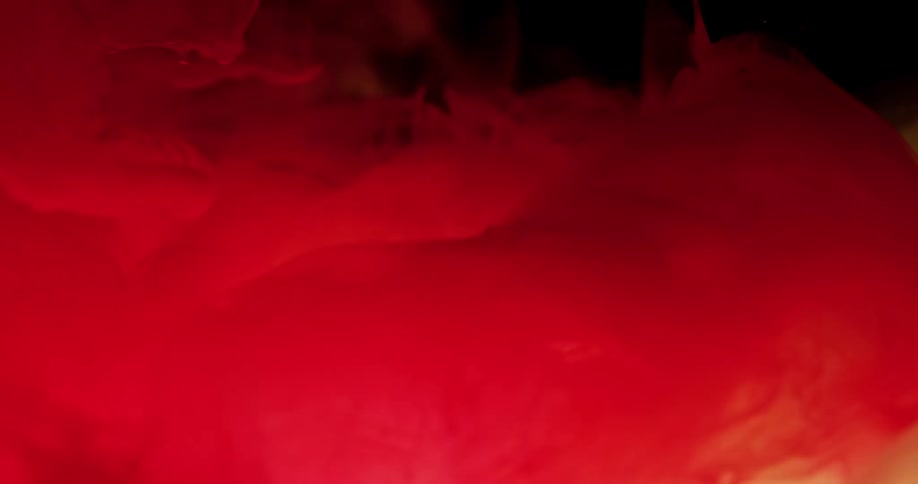 The red clouds mix in the dark liquid