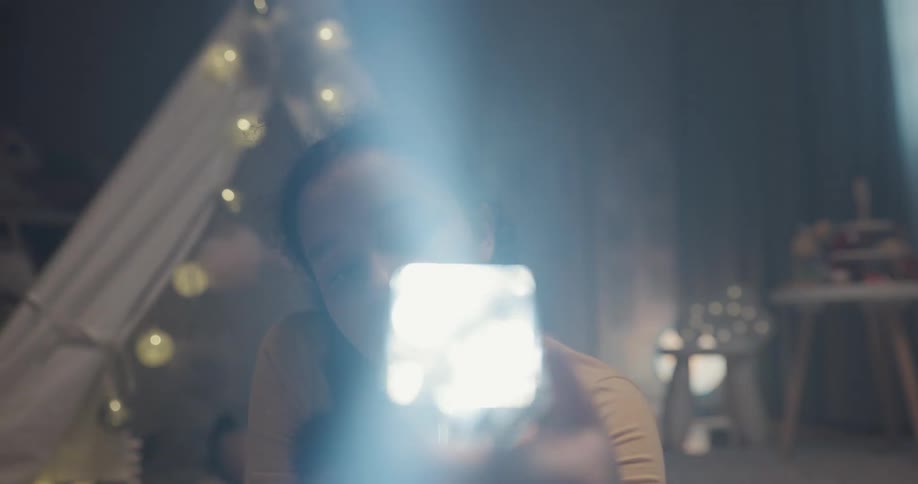A teenage girl shines flashlight in to a crystal block